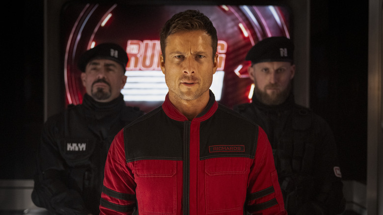 Ben Richards walking out onto the Running Man soundstage flanked by guards in The Running Man