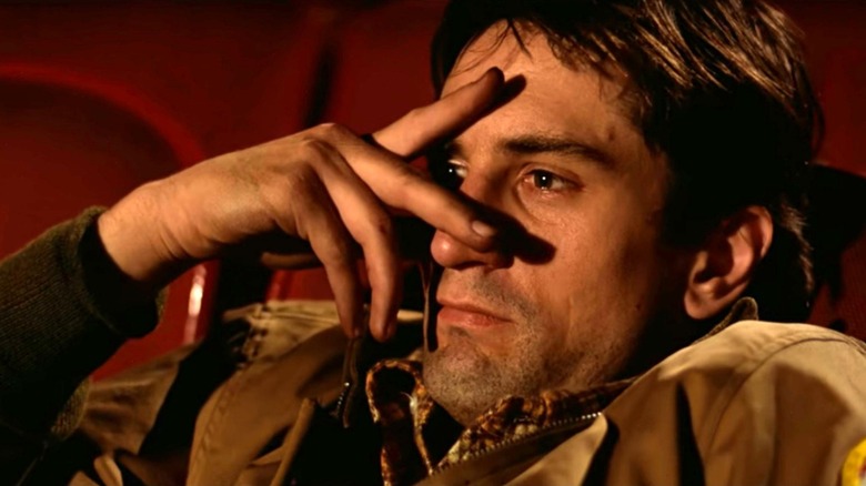Travis Bickle with a hand over his face in Taxi Driver (1976)