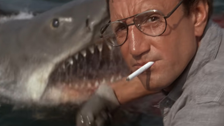 Brody throws chum, aware of the shark behind him in Jaws (1975)