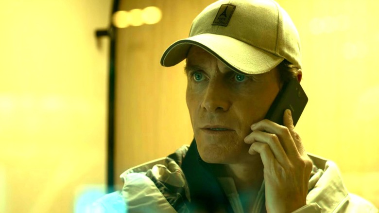 The Killer takes a phone call in The Killer (2023)