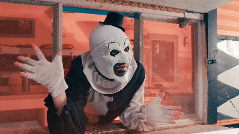 Art the Clown waving before bloody chaos ensues in "Terrifier 2" (2022)