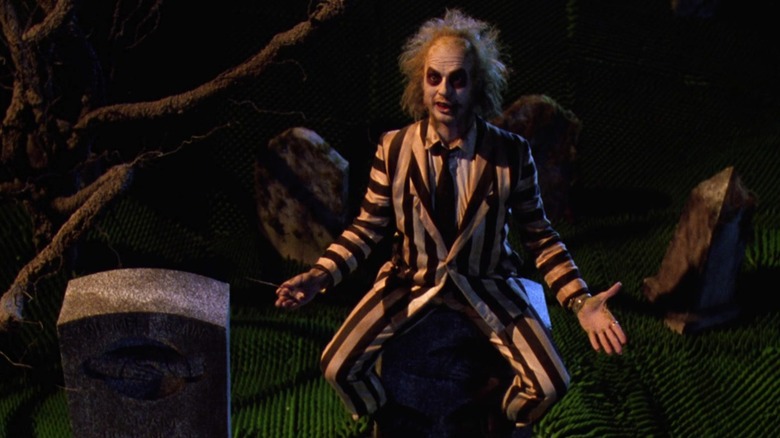 Beetlejuice sits on a tombstone in "Beetlejuice" (1988)