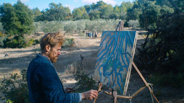 Vincent Van Gogh sitting and painting a canvas on an easel in nature