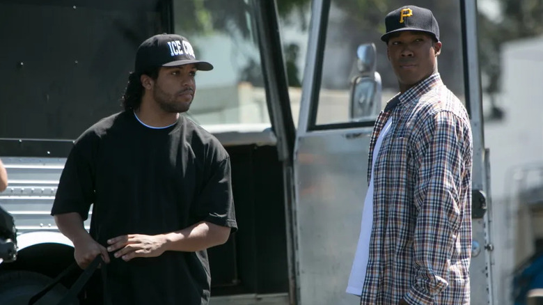 Ice Cube and Dr. Dre talking in front of their travel bus