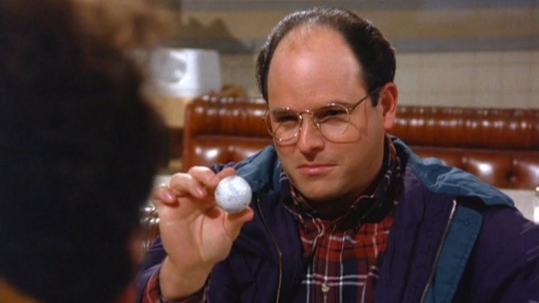 George holds up a golf ball in "The Marine Biologist"