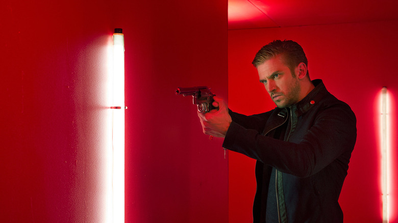 David Collins drawing out a gun in The Guest