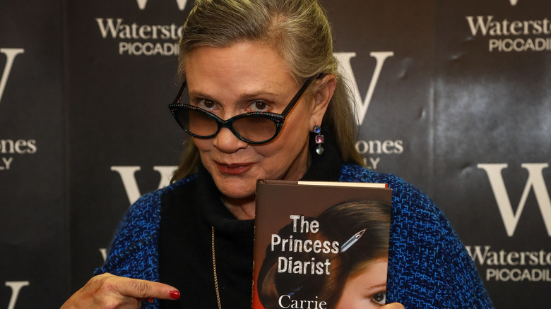 Carrie Fisher points to her book, The Princess Diarist