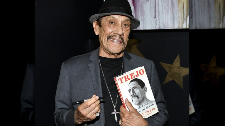 Danny Trejo holding his book