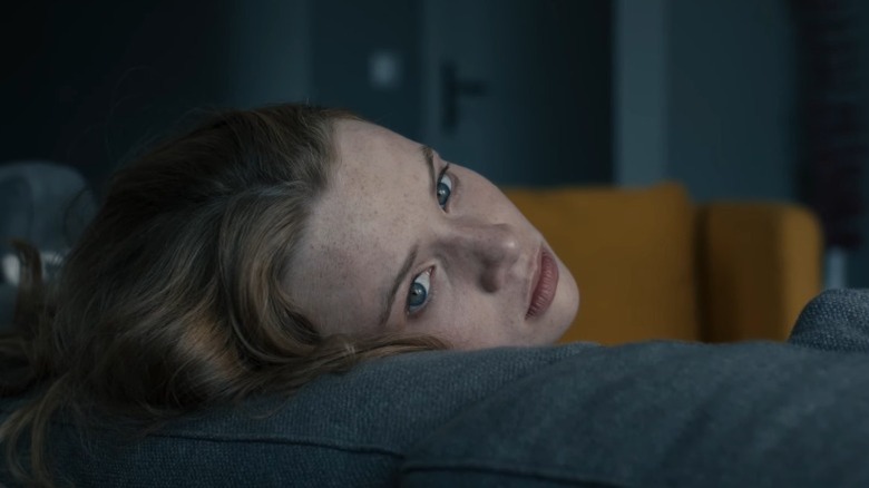 Mia resting her head on a couch back pillow in Blue My Mind