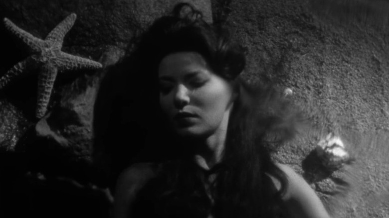 Mora lying on the seabed next to a starfish in Night Tide