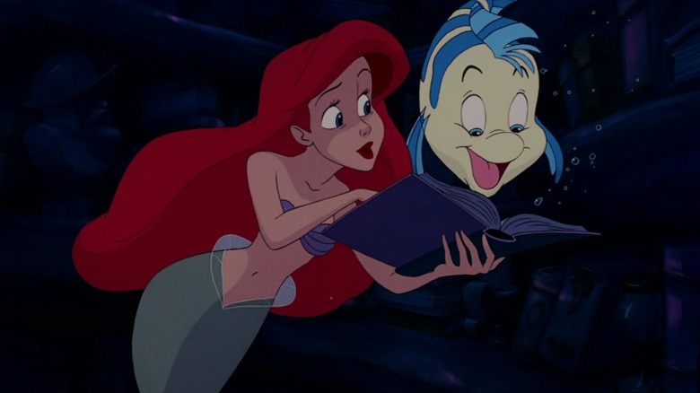 Ariel showing a book to Flounder in The Little Mermaid