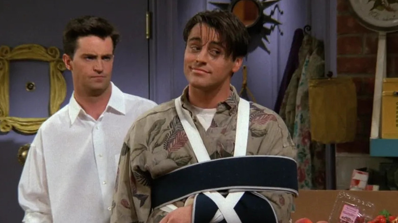 Chandler and Joey, who has his left arm in a sling, looking suspicious on "Friends" (1994-2004)