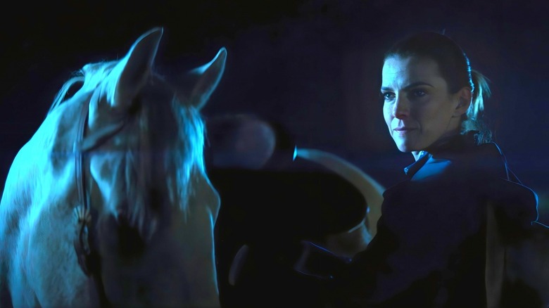 Simone smirks beside horse