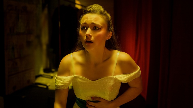 Lori Granger looking scared holding stomach in Fear Street: Prom Queen