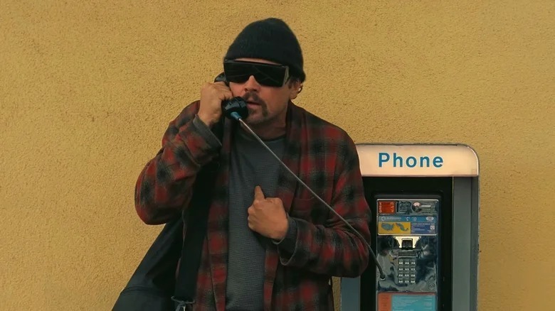 Pat Calhoun using a payphone in One Battle After Another