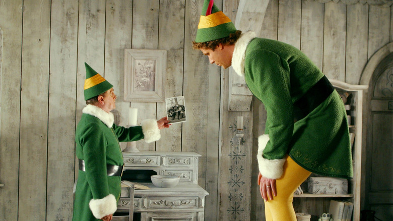 Papa Elf and Buddy talk and look at a photo