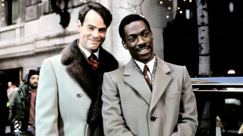 Dan Aykroyd and Eddie Murphy smile triumphantly