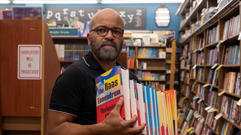 Monk holding a bunch of his own books in American Fiction
