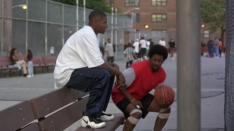 Jesus (Ray Allen) sits on a bench while Jake (Denzel Washington) bounces a basketball in He Got Game.