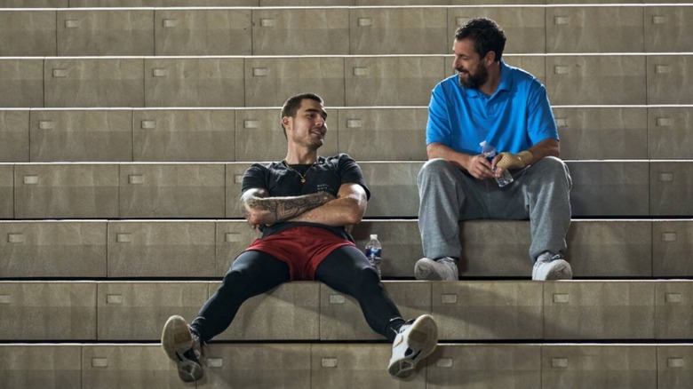 Stanley (Adam Sandler) and Bo (Juancho Hernangomez) sit on the bleachers in Hustle