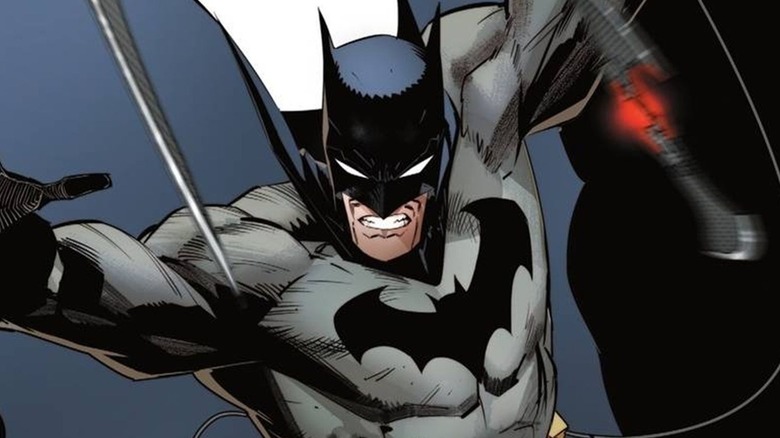 Batman throwing Batarangs at an unseen enemy