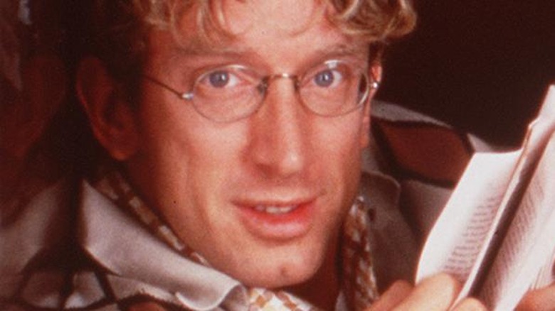 Andy Dick posing with a book