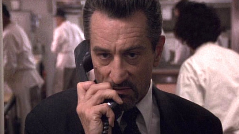 Neil McCauley holding phone up to his ear in Heat