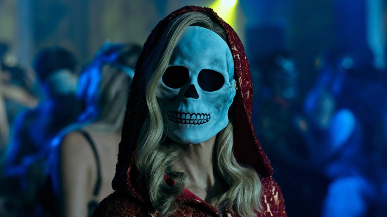 A woman in a skull mask at a masquerade in 