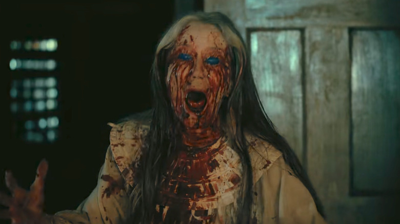 A nightmarish woman covered in blood screams in "The Fall of the House of Usher" (2023)