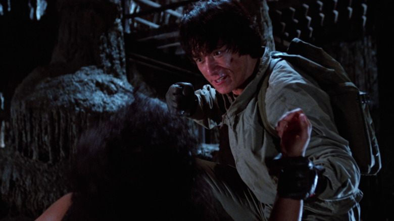 Jackie grabbing a man's wrist and getting ready to punch him in Armour of God
