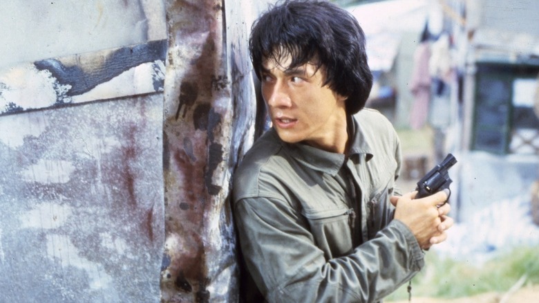 Ka-Kui holding gun behind a corner in Police Story