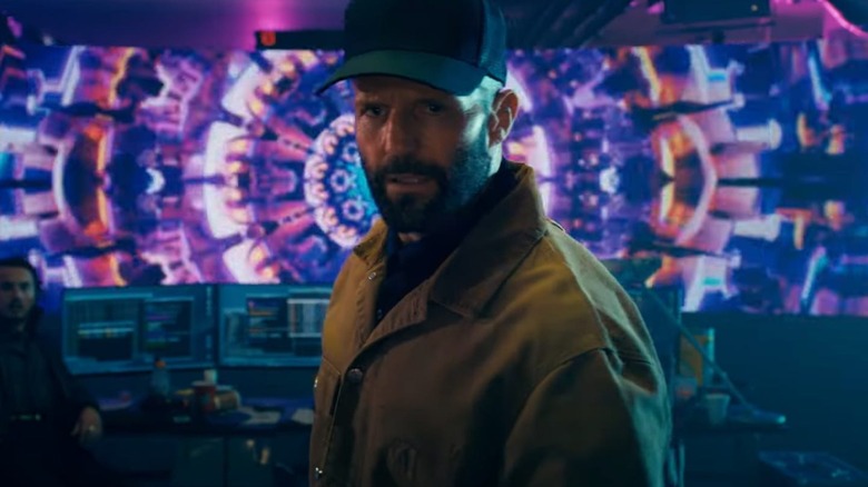 Clay stands in a high tech data center in "The Beekeeper" (2024)