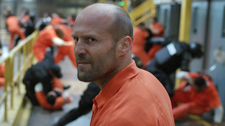 Shaw stands calmly in the middle of a prison riot in "The Fate of the Furious" (2017)