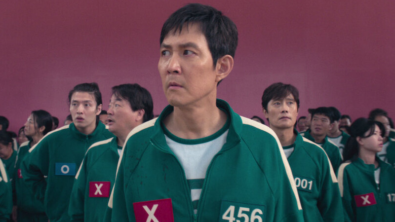 Gi-hun with many players behind him in Squid Game (2021)
