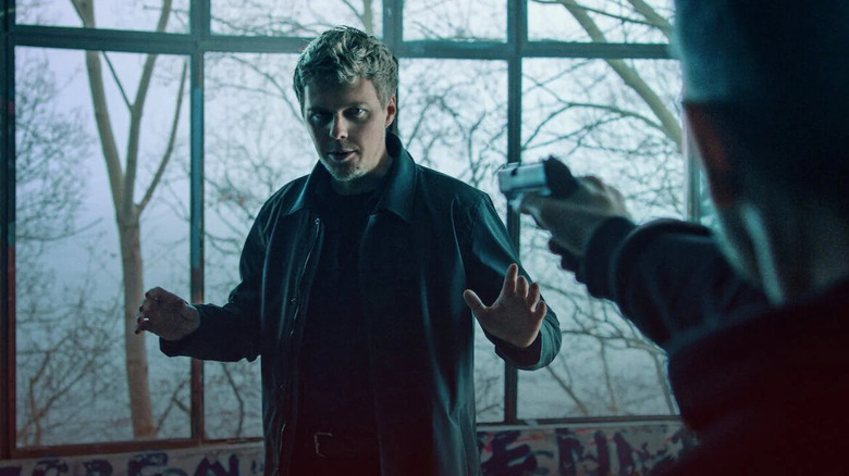 Leopold holds up his hands while a shadowy figure holds him at gunpoint in Colors of Evil: Red