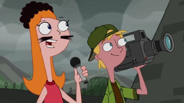 Candace wearing a wig and a fake mustache and holding a microphone next to Jeremy holding a camera