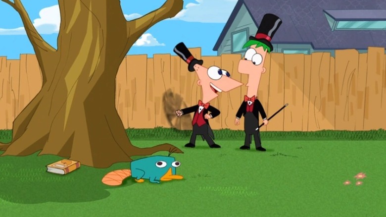 Phineas and Ferb dressed in suits and top hats in their backyard
