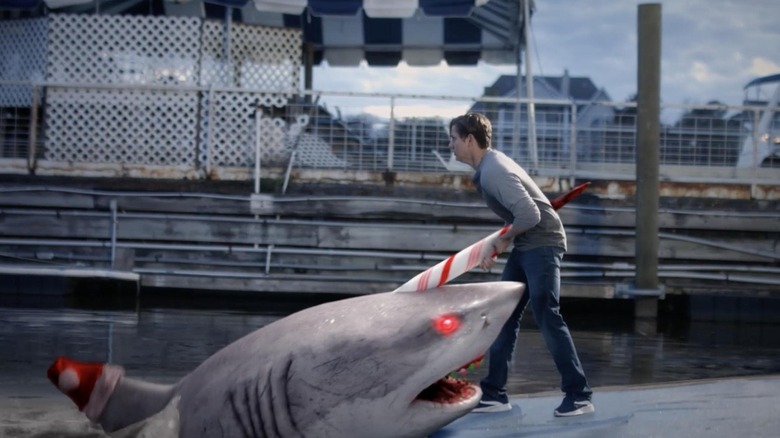 Man being impaled by a shark with red and white horn in "Santa Jaws"