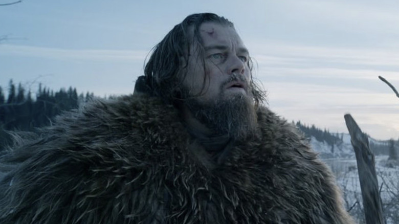 A fur-clad Hugh Glass stands in snowy wilderness in "The Revenant" (2015)