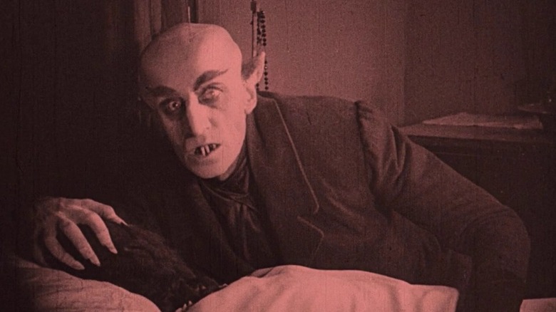 Count Orlok bending over a victim in "Nosferatu"