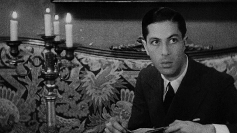 Allan Gray sitting on a sofa in "Vampyr"