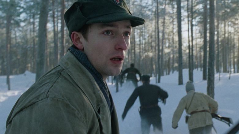 A panicked Gunnar looks over his shoulder in the woods in Number 24 (2024)