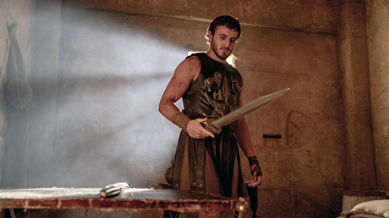 Lucius looking at a sword