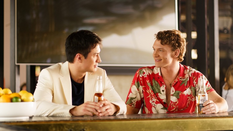 Shane Hollander and Ilya Rozanov smiling at each other at a bar in Heated Rivalry (2025)