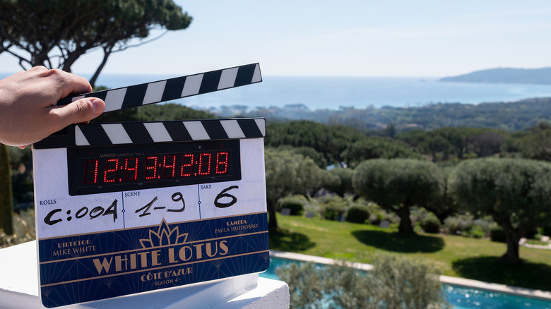 A promotional image for The White Lotus season 4 (2027) showing a clapperboard against a scenic vista