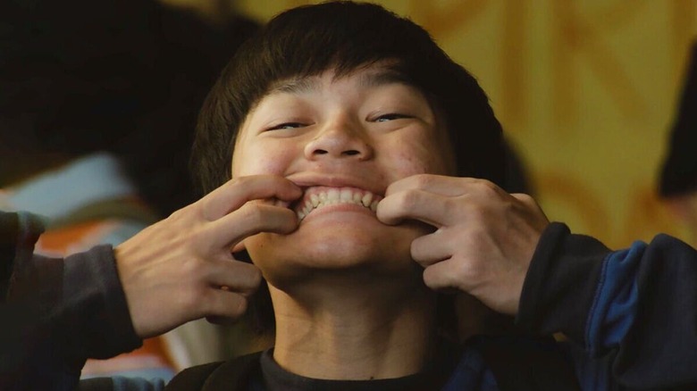 Chris holding his mouth open in a big smile in "Dìdi"