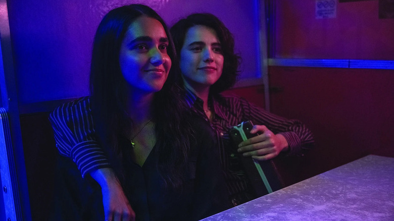 Marian and Jamie sit in a bar booth in "Drive-Away Dolls"