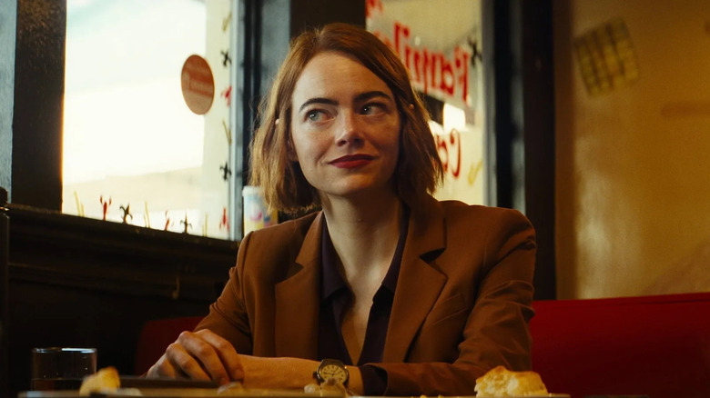 Emily sits in a diner in "Kinds of Kindness"