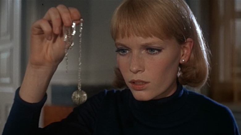Rosemary holds up a necklace in "Rosemary's Baby" (1968)