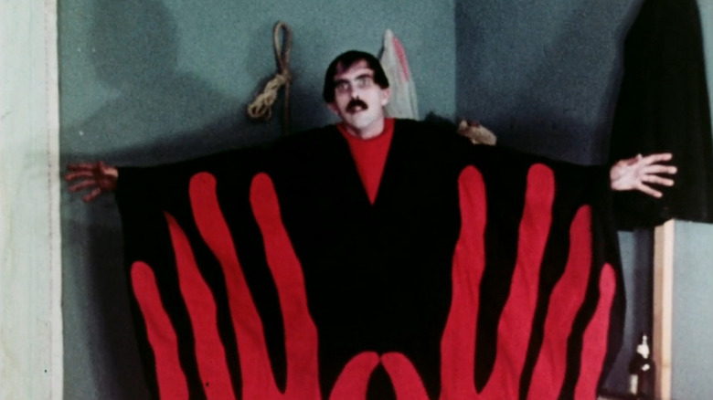 The Master standing with his arms spread in "Manos: The Hands of Fate" (1966)
